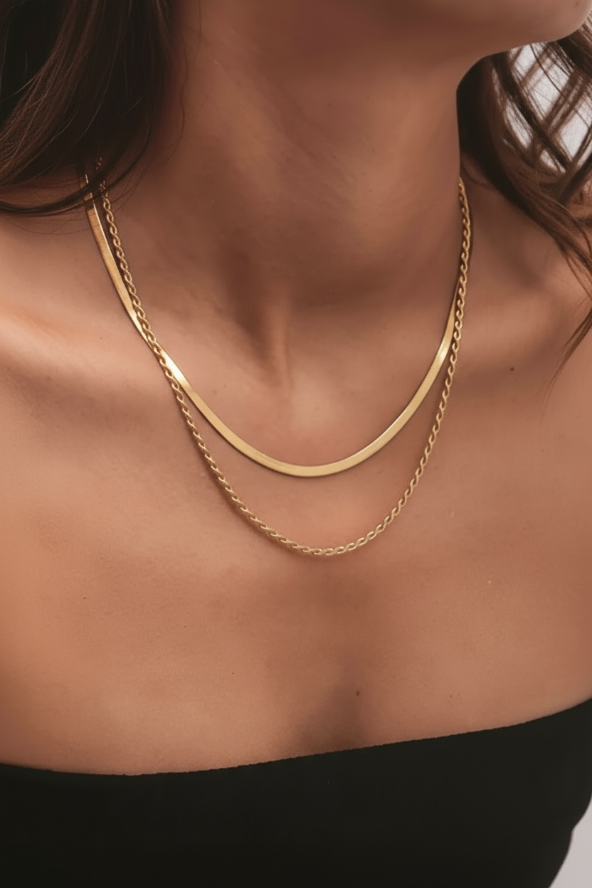 Gold necklace on a person's neck with a neutral background